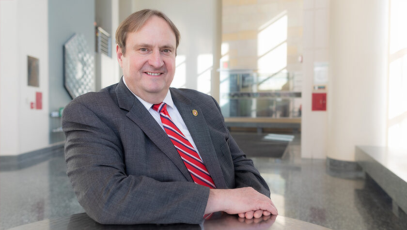 An environmental portrait of Steve Swanson in the sun-brightened atrium of the School of Pharmacy.