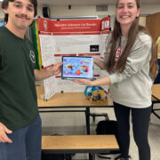 PharmD students hold a tablet at a health fair booth