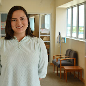 Maya Boguslawski stands in a waiting room and smiles