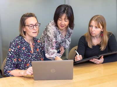 Kate Rotzenberg, Michelle Chui, and Jamie Stone looking at a computer