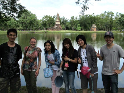 Katie Hanke with a group of Thai pharmacy students standing in front of a body of water