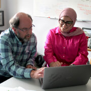 Jay Ford and Sura AlMahasis work together at a laptop