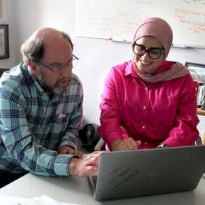 Jay Ford and Sura AlMahasis work together at a laptop