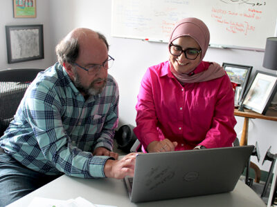 Jay Ford and Sura AlMahasis work together at a laptop