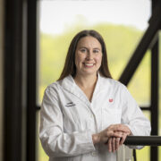 Jenny Donar poses in front of a window in her white coat