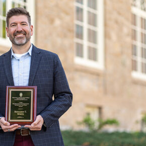 Ben White poses with his award plaque outside
