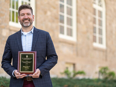 Ben White poses with his award plaque outside