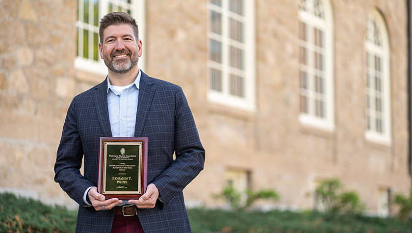Ben White poses with his award plaque outside