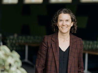 Susie Barnett poses for a photo, wearing a brown blazer