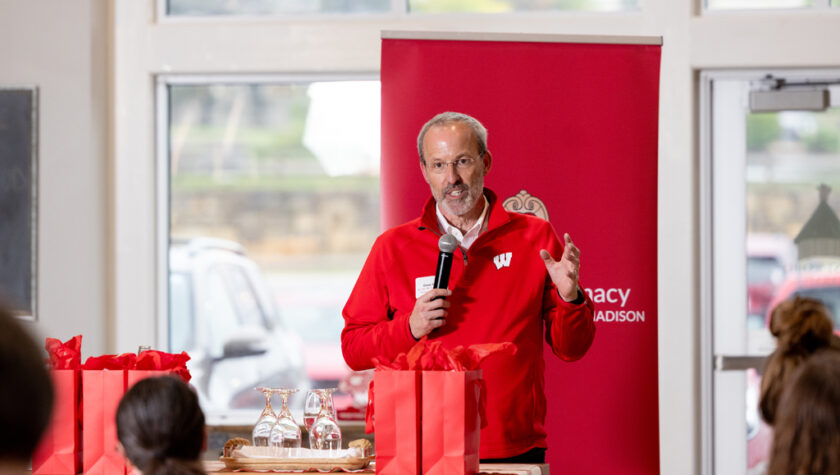 Dave Mott standing in front of the School of Pharmacy banner