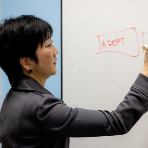 Michelle Chui writes on a dry erase board