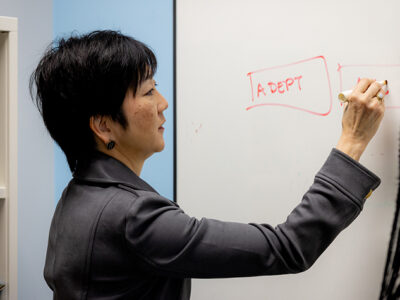Michelle Chui writes on a dry erase board