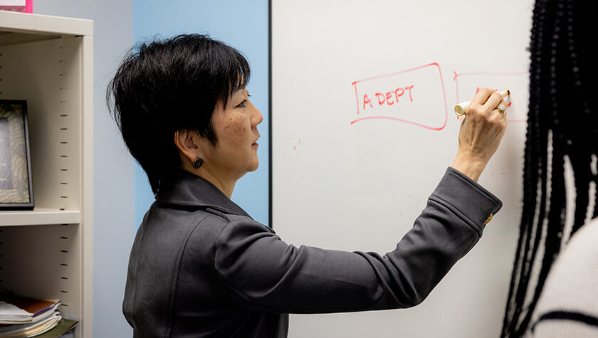 Michelle Chui writes on a dry erase board