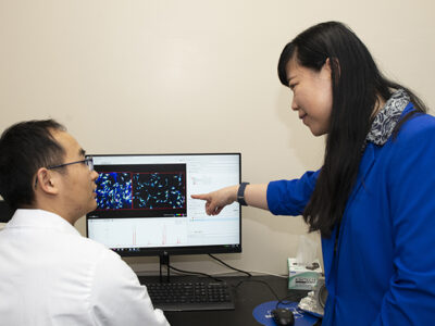 Lingjun Li and Hua Zhang working at a computer
