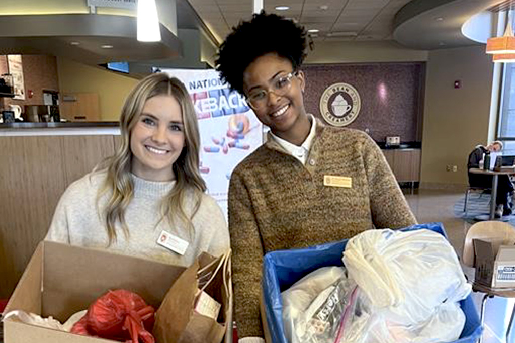 PharmD students hold boxes of medications collected at a community medication drop-off event.