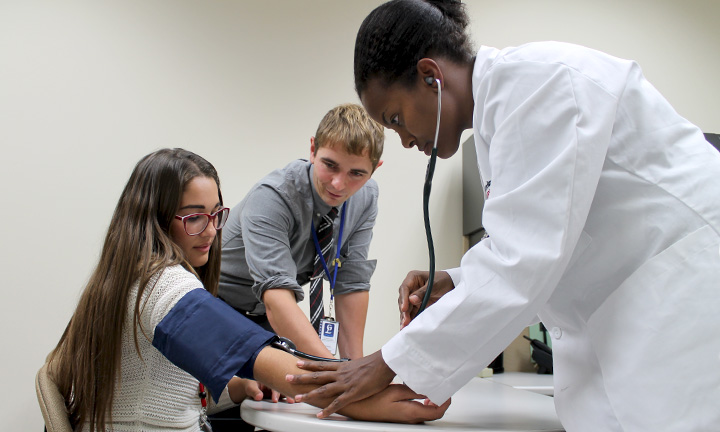 Mike Nagy helping instruct students take blood pressure