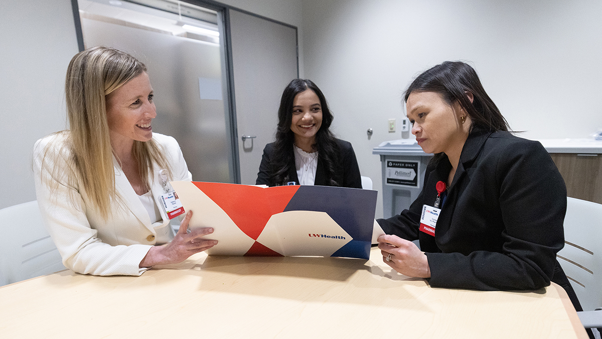 Kristina Hiemerl, Jaynika Patel, and Connie Vo review documents in a conference room