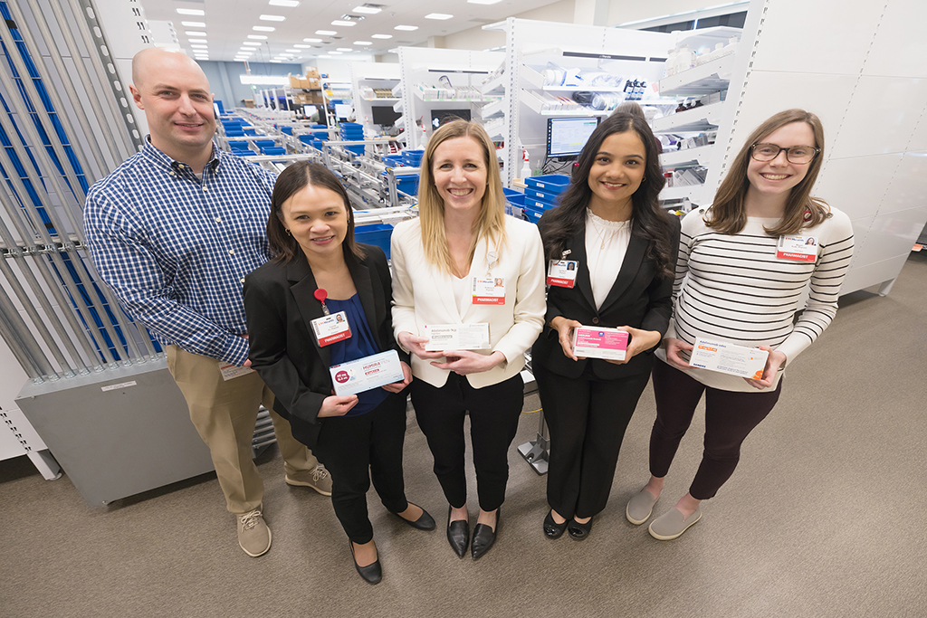 Jim Langely, Connie Vo, Kristina Heimerl, Jaynika Patel, and Megal Kuik pose with boxes of specialty medications to treat IBD.