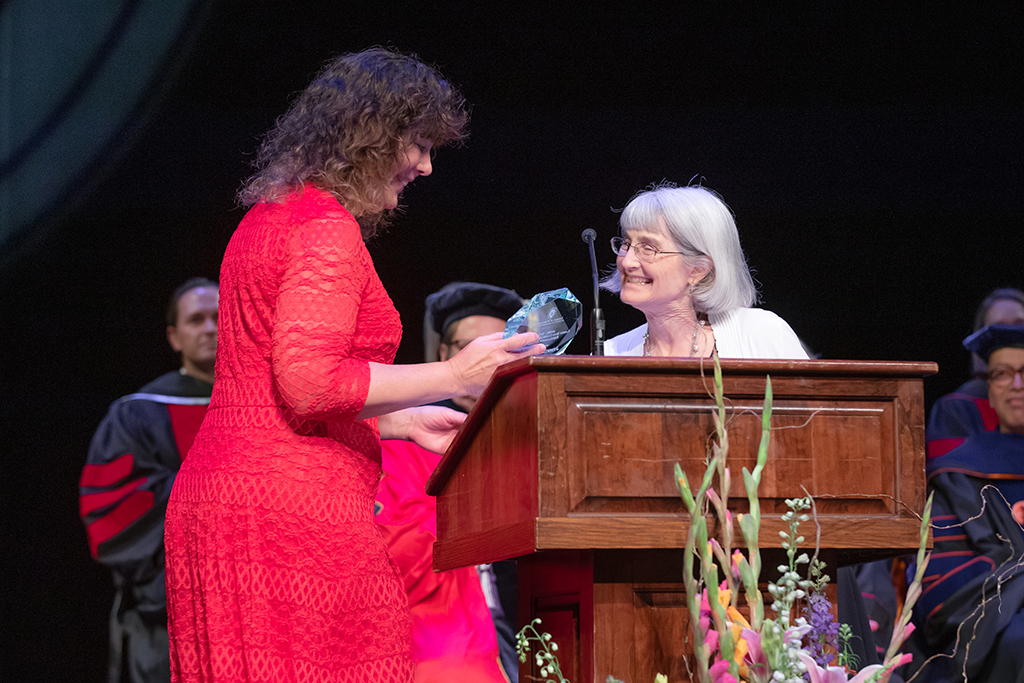 Jenny Moran smiles at Mara Kieser and Mara hands her the award.