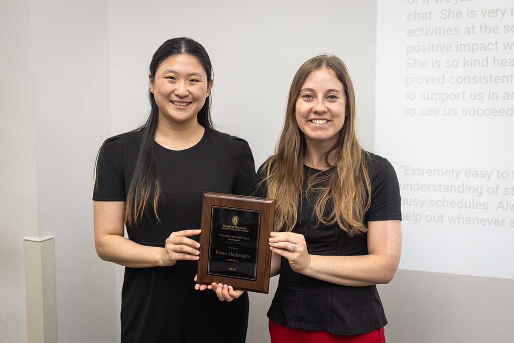 Two women hold an award plaque in their hands