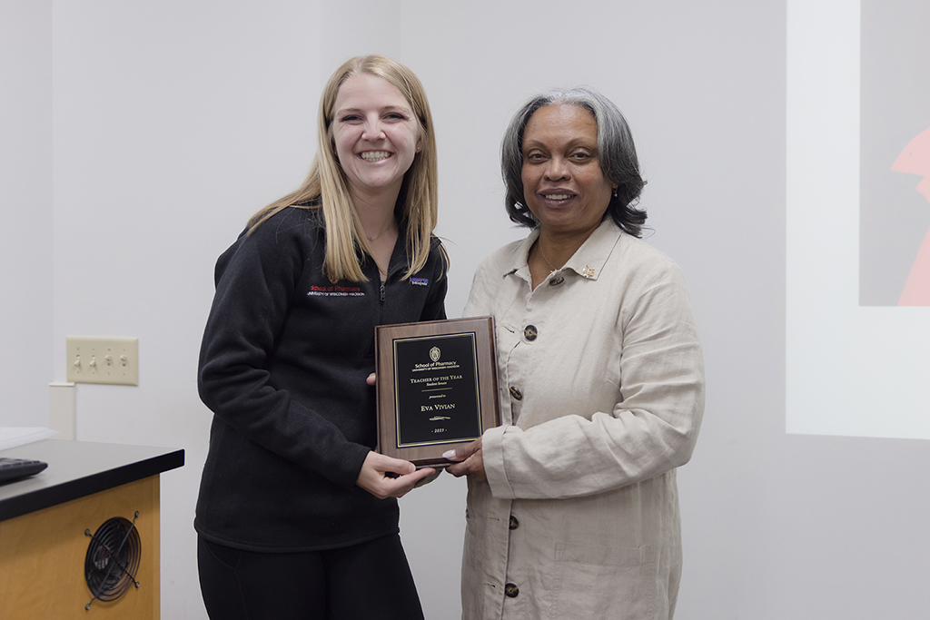 Grace Klubertanz and Eva Vivian, holding a Teacher of the Year plaque