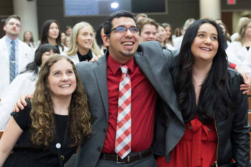 Arm in arm, School of Pharmacy faculty sing