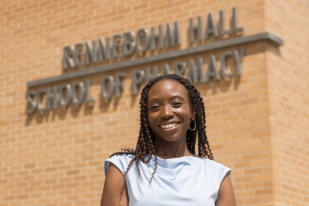 Tiffany Parham poses in front of a sign that reads Rennebohm Hall School of Pharmacy