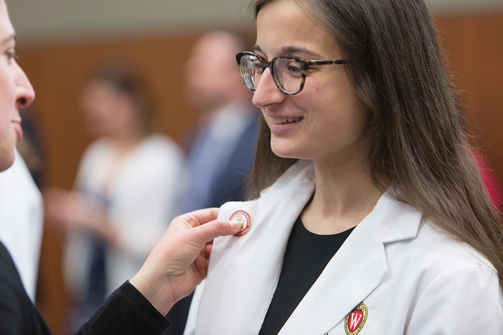A student accepts pin from the school faculty.