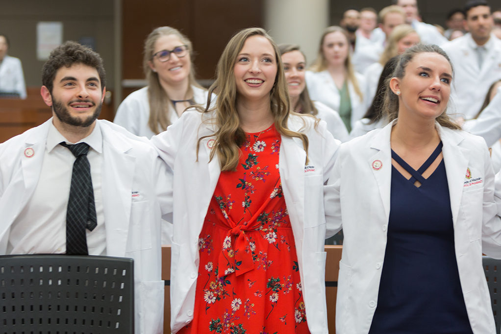 Student pharmacists locking arms during the ceremony