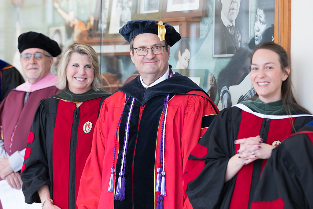 Mel de Villiers, Debra Fluno, Dean Steve Swanson, and Kate Rotzenberg stand in the hallway before the ceremony.