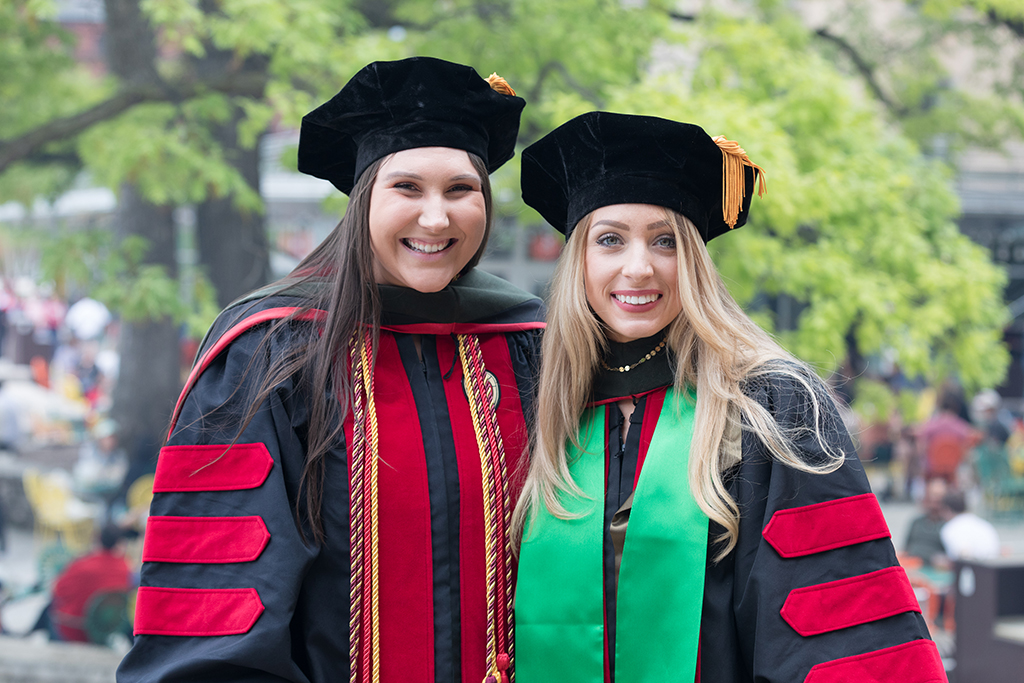 Two female School of Pharmacy graduates pose for a photo.