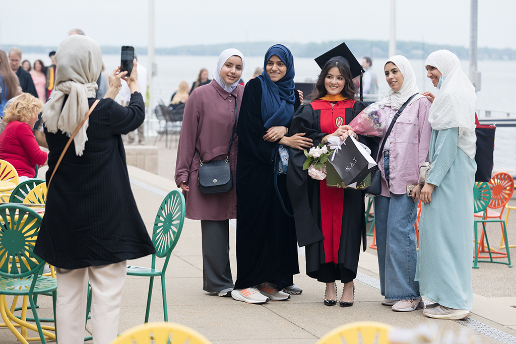 A School of Pharmacy graduate celebrates outside with her family and poses for a group photo.