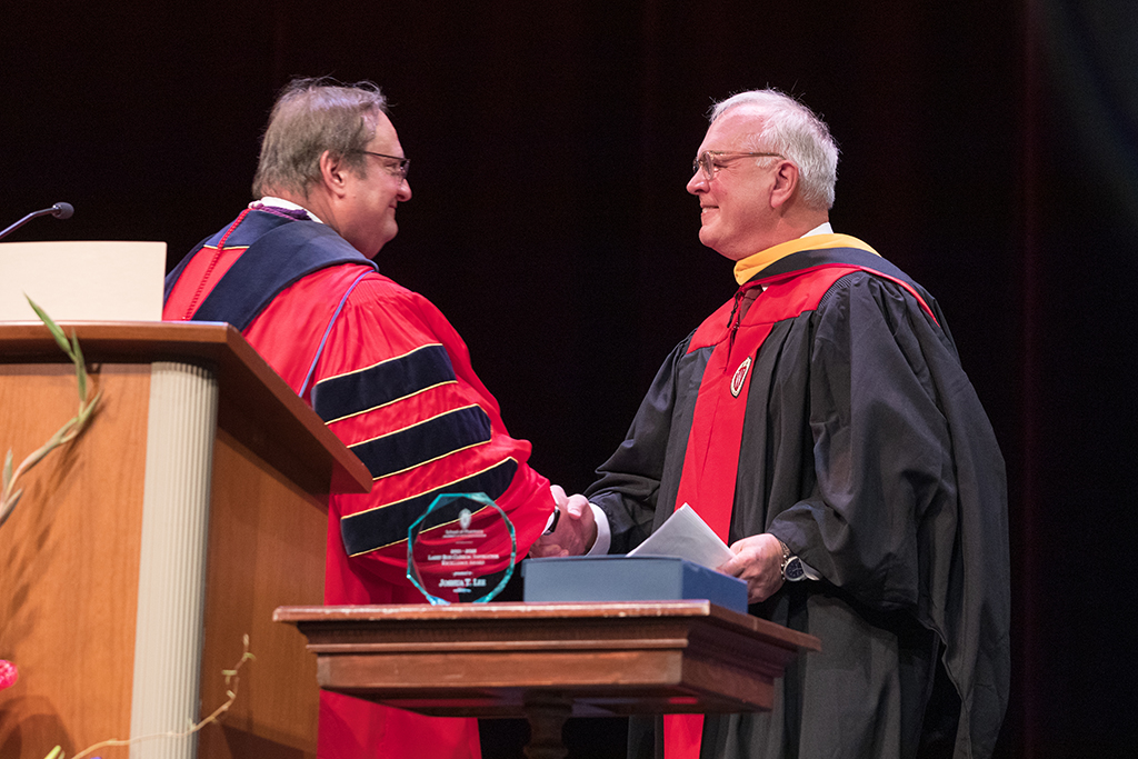 Dean of the School of Pharmacy Steve Swanson shaking hands with professor