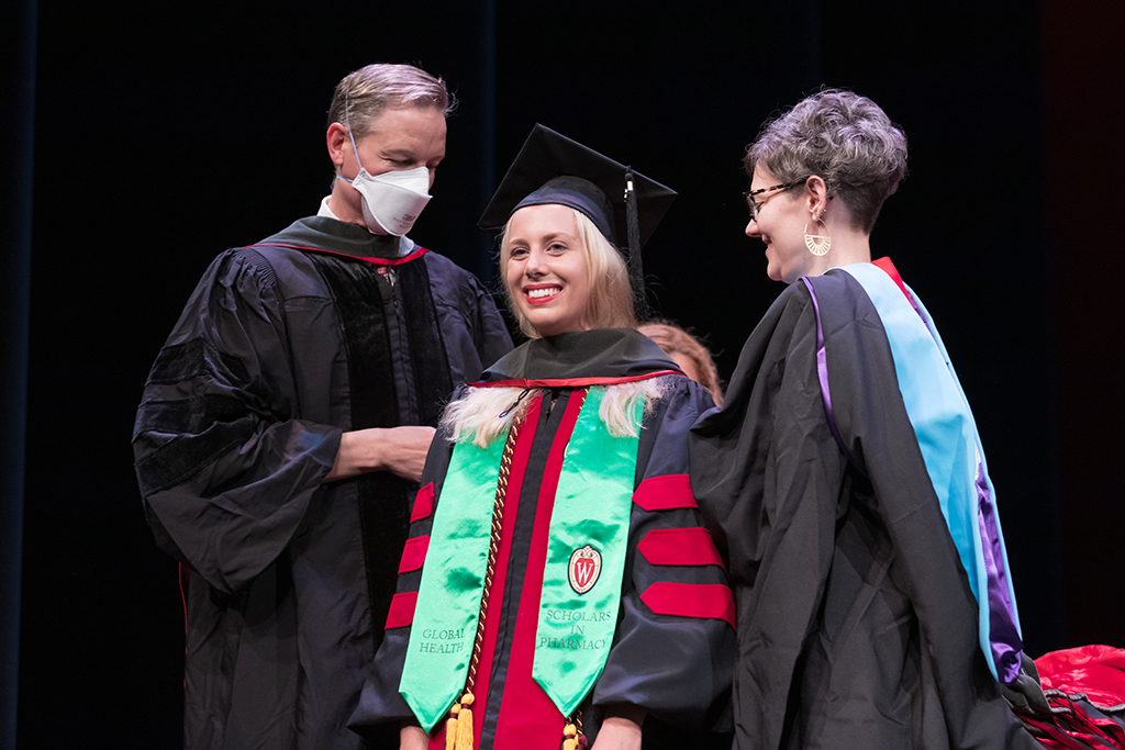 Class of 2022 PharmD graduate Megan Avery receives her hood from Professor John Dopp and Advisor Rebecca Beebe