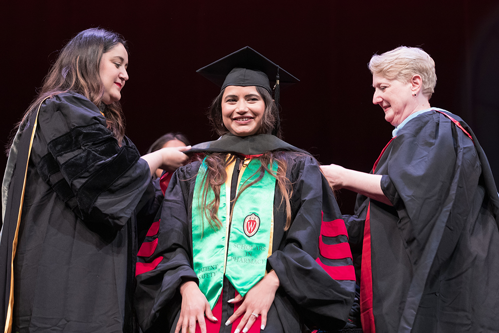 Class of 2022 PharmD graduate Sandeep Brar receives her hood from Professors Marina Maes and Karen Kopacek