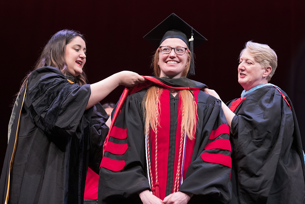 Class of 2022 PharmD graduate Kaitlin Bruden receives her hood from Professors Marina Maes and Karen Kopacek