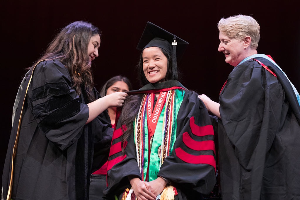 Class of 2022 PharmD graduate Stephaney Cheng receives her hood from Professors Marina Maes and Karen Kopacek