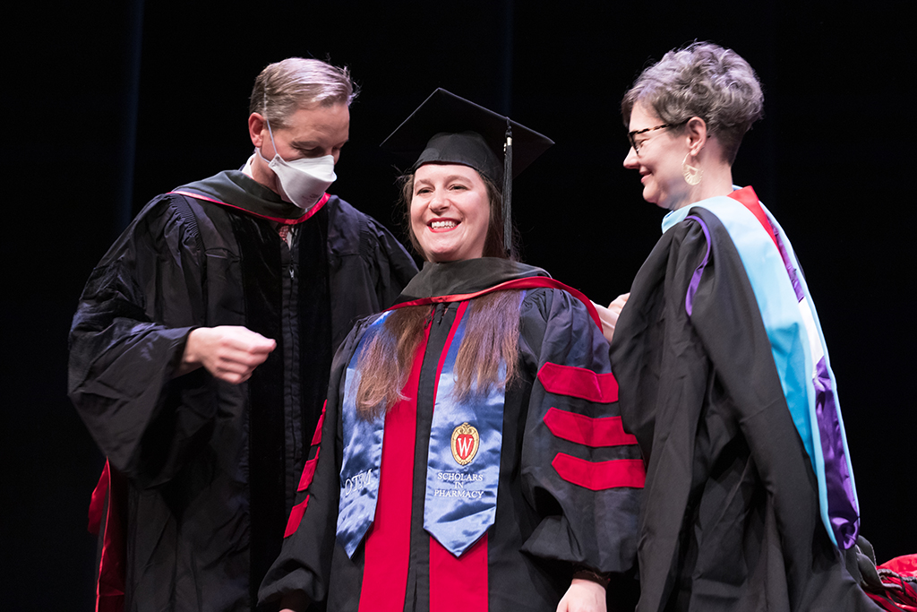Class of 2022 PharmD graduate Nicole Donovan receives her hood from Professor John Dopp and Advisor Rebecca Beebe