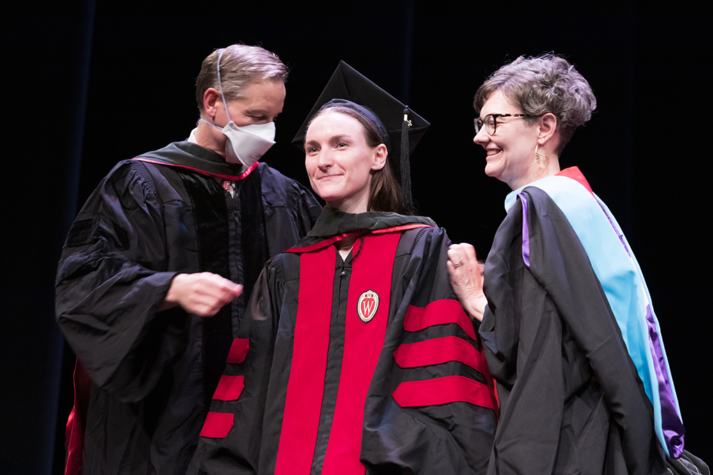 Class of 2022 PharmD graduate Mary Fanshaw receives her hood from Professor John Dopp and Advisor Rebecca Beebe