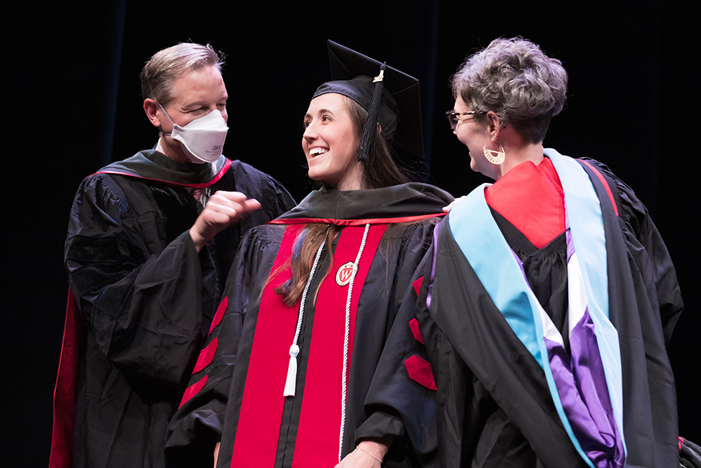 Class of 2022 PharmD graduate Emily Willey receives her hood from Professor John Dopp and Advisor Rebecca Beebe