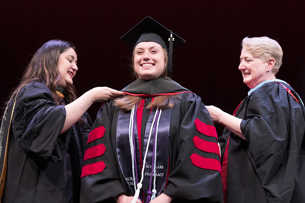 Class of 2022 PharmD graduate Stephanie Garvin receives her hood from Professors Marina Maes and Karen Kopacek
