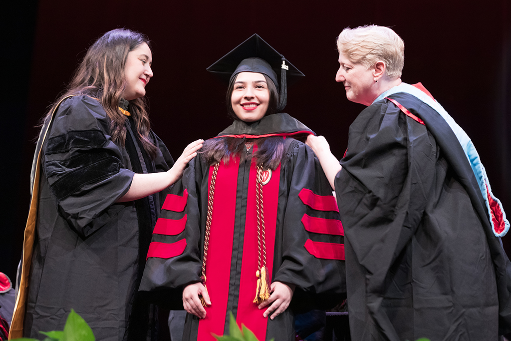 Class of 2022 PharmD graduate Mahnoor Khan receives her hood from professors Marina Maes and Karen Kopacek