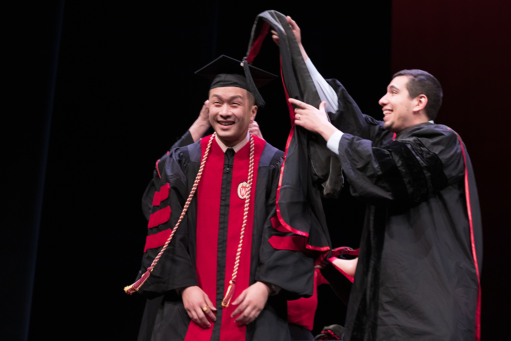 Class of 2022 PharmD graduate Tai Lu receives his hood from Professors Bonnie Fingerhut and Ed Portillo