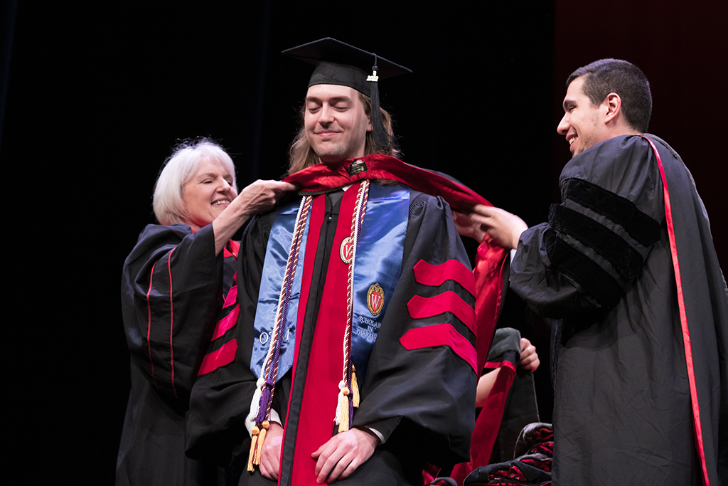 Class of 2022 PharmD graduate Alexander Mohr receives his hood from Professors Bonnie Fingerhut and Ed Portillo