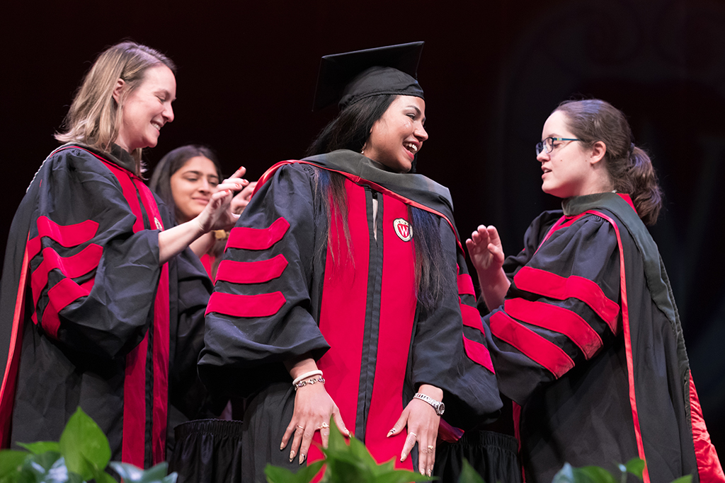 Class of 2022 PharmD graduate Niraliben Patel receives her hood from professors Kate Rotzenburg and Amanda Margolis