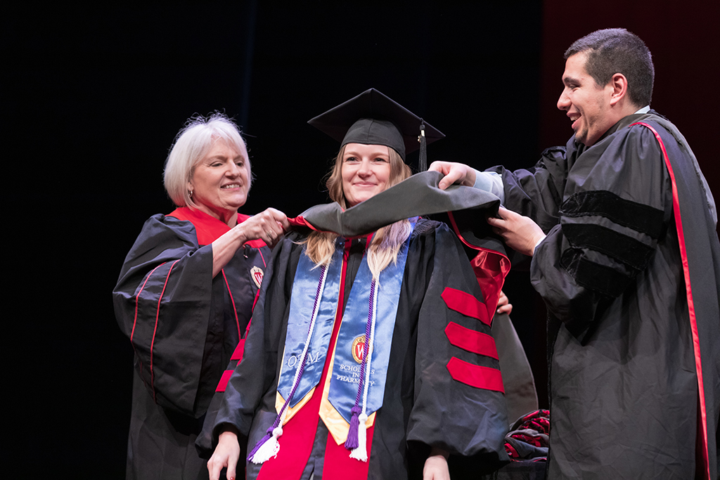 Class of 2022 PharmD graduate Rachel Russ receives her hood from Professors Bonnie Fingerhut and Ed Portillo