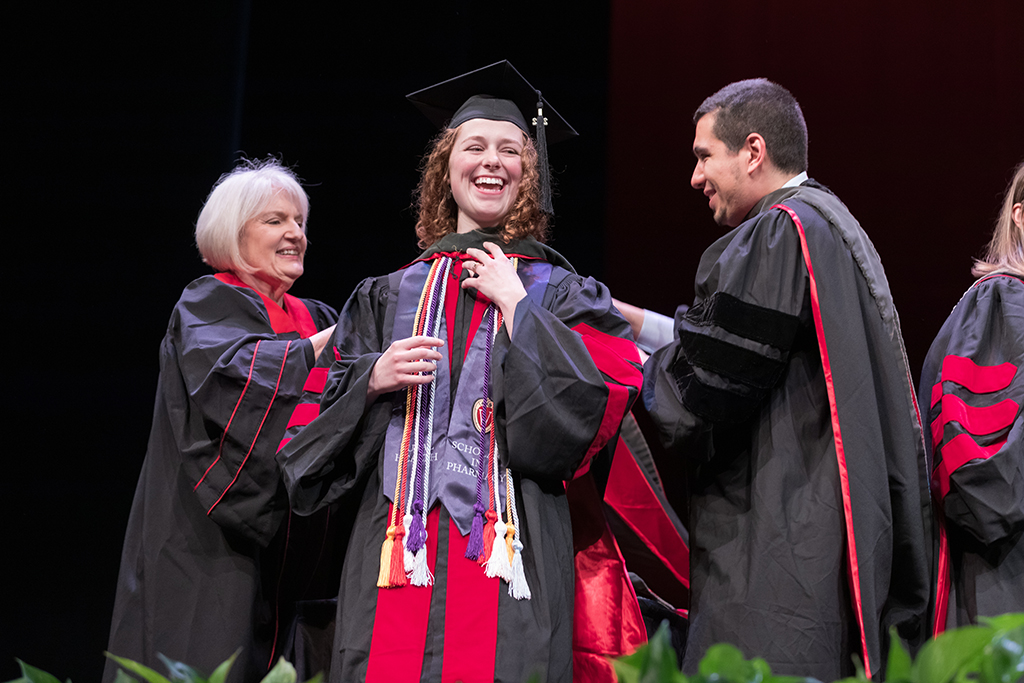 Class of 2022 PharmD graduate Johanna Van Epps receives her hood from Professors Bonnie Fingerhut and Ed Portillo