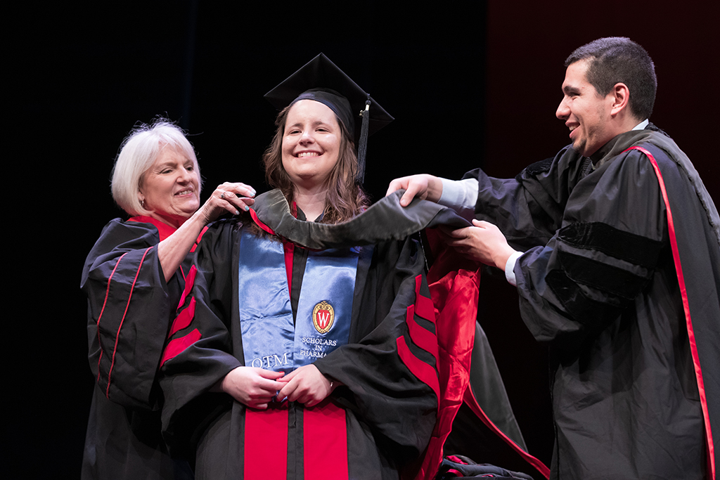Class of 2022 PharmD graduate Kristen Wendler receives her hood from Professors Bonnie Fingerhut and Ed Portillo
