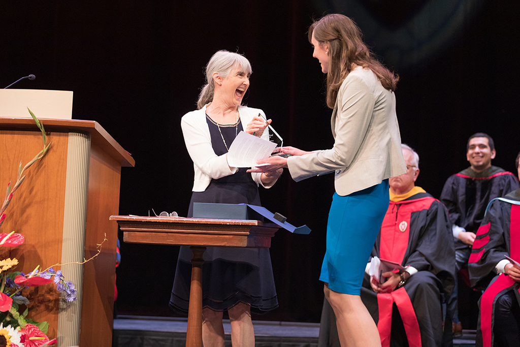 Kate Hartkopf receiving award from faculty member at SoP hooding ceremony