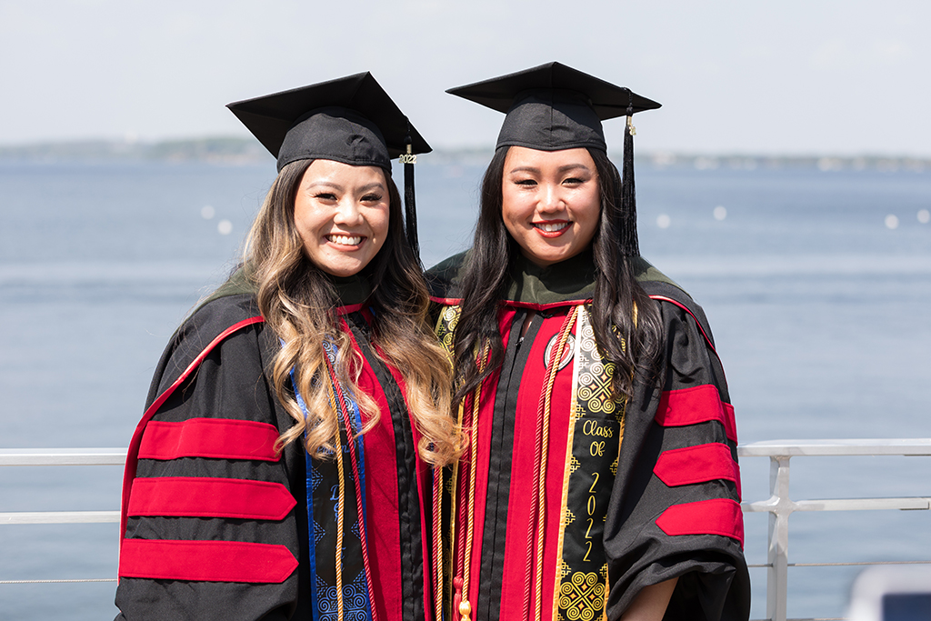 Class of 2022 PharmD graduates Der Lor and Tracy Lor pose together in their caps and gowns at Memorial Union Terrace after the Hooding Ceremony
